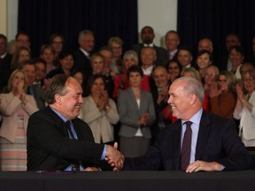 B.C. NDP Leader John Horgan, right, and B.C. Green party Leader Andrew Weaver shake hands after signing a deal on creating a stable minority government during a news conference in the Hall of Honour at the legislature in Victoria on May 30.