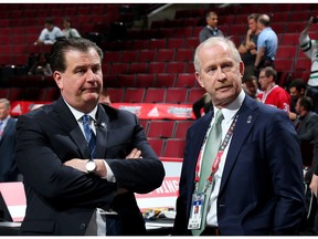 Vancouver Canucks general manager Jim Benning, left, meets with Dallas Stars GM Jim Nill on Friday at the NHL entry draft at the United Center in Chicago.