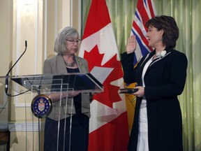 Premier Christy Clark takes an oath with Lieutenant-Governor Judith Guichon as she's sworn-in during ceremony with the provincial cabinet at Government House in Victoria, B.C., on Monday, June 12, 2017.