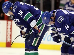 Victor Oreskovich, left, and Alex Burrows of the Vancouver Canucks hang their heads after the Boston Bruins beat the Canucks in Game 7 of the 2011 Stanley Cup Final at Rogers Arena.