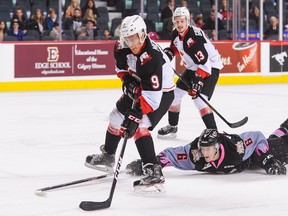 Brad Morrison of the Prince George Cougars skates past Jaydan Gordon of the Calgary Hitmen during a WHL game at Scotiabank Saddledome on October 29, 2016 in Calgary.