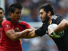 New Zealand's Akira Ioane (R) hands off Canada's Sean Duke (L) during the Rugby Sevens Pool A game between New Zealand and Canada at Ibrox during the 2014 Commonwealth Games in Glasgow, Scotland on July 26, 2014. New Zealand won the game 39-0.