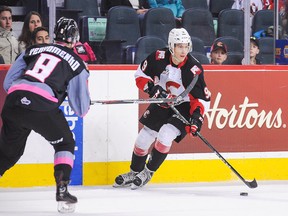 Brad Morrison of the Prince George Cougars skates with the puck against Vladislav Yeryomenko of the Calgary Hitmen during a WHL game at Scotiabank Saddledome on October 29, 2016 in Calgary.