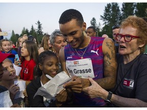 Canadian sprint star Andre De Grasse signs autographs after winning the men's 100-metre event on Wednesday night at the 2017 Vancouver Sun Harry Jerome Track Classic at Percy Perry stadium in Coquitlam.