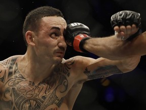 American Max Holloway, left, fights Jose Aldo, out of frame, of Brazil during their UFC featherweight mixed-martial-arts bout in Rio de Janeiro on June 4.