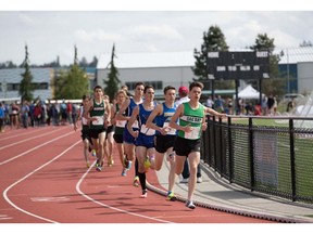 Tyler Dozzi of Oak Bay, in green, leads the senior boys' 3,000-metres in Langley. He eventually finished second behind Charlie Dannatt.