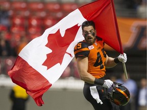B.C. Lions linebacker Jason Arakgi carries the Canadian flag onto the field prior game against the Toronto Argonauts at B.C. Place last season. Arakgi, the CFL's all-time leader in special teams tackles, announced he's retiring to pursue a job outside football.