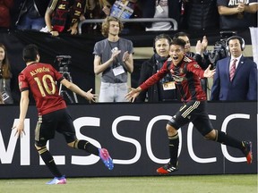 Midfielder Yamil Asad of Atlanta United, right, celebrates with midfielder Miguel Almiron after Asad scores the first goal of the game — and the first goal in Atlanta United history — against the New York Red Bulls at Bobby Dodd Stadium on March 5 in Atlanta. It was the first of 27 goals they've scored this season, tied for tops in MLS.