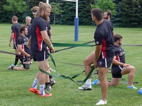 Canada rugby team forward Evan Olmstead (left) looks to untangle himself after stretching at practice in Markham, Ont., Tuesday, June 20, 2017. THE CANADIAN PRESS/Neil Davidson