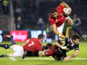 British and Irish Lions' Taulupe Faletau (top) looks to break a tackle during the rugby match between New Zealand's Provinial Barbarians and the British and Irish Lions at Toll Stadium in Whangarei on June 3, 2017.