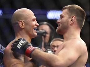 Stipe Miocic, right, hugs Junior Dos Santos after their heavyweight championship bout at May's UFC 211 in Dallas. Miocic retained his heavyweight title. Despite being a world champion and millionaire, Miocic still works as a firefighter.