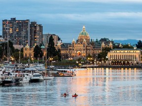 The B.C. Parliament Buildings, lit up at night, overlooking Victoria's Inner Harbour.