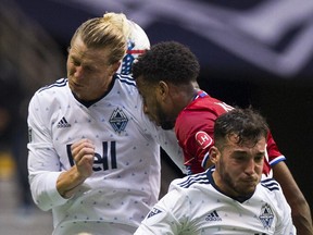 FC Dallas's Kellyn Acosta is caught between Vancouver Whitecaps Brek Shea, left, and Russell Teibert during Saturday night's game at B.C. Place. The game ended in a 1-1 tie.