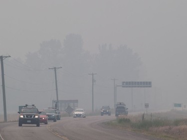 Smoke from wildfires blankets the area as motorists travel on the Yellowhead Highway in Little Fort, B.C., on Saturday July 8, 2017.