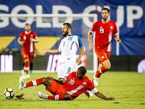 Canada midfielder Patrice Bernier (20) makes a slide tackle on Honduras midfielder Alfredo Mejia (8) during the first half of a CONCACAF Gold Cup soccer match Friday, July 14, 2017, in Frisco, Texas. (Smiley N. Pool/The Dallas Morning News via AP)