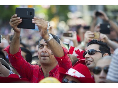 A man records the crowd singing O Canada at the Canada Day celebrations at Canada Place, Vancouver, July 01 2017.