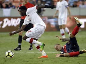 Costa Rica's David Ramirez, right, hits the ground after being tackled by Canada's Alphonso Davies, left, in the second half of a CONCACAF Gold Cup soccer match in Houston, Tuesday, July 11, 2017.