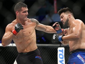 UNIONDALE, NY - JULY 22: Chris Weidman (L) lands a left hook on Kelvin Gastelum (R) during their UFC Fight Night middleweight bout at the Nassau Veterans Memorial Coliseum on July 22, 2017 in Uniondale, New York. (Photo by Ed Mulholland/Getty Images)