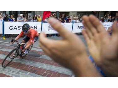 Riders in the women's  Global Relay Gastown Grand Prix are cheered on by a spectator , Vancouver, July 12 2017.