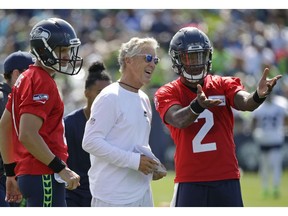 Pete Carroll, the head coach of the Seattle Seahawks, speaks with backup quarterbacks Austin Davis, left, and Trevone Boykin during the first day of National Football League training camp on Sunday in Renton, Wash.