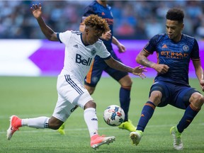 Yordy Reyna, left, tries to move the ball past New York City FC's Alexander Callens during the second half of an MLS soccer game in Vancouver, B.C., on Wednesday July 5, 2017.