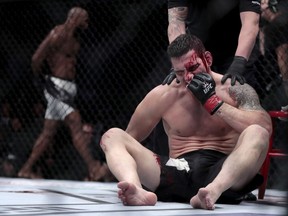 Chris Weidman sits in the octagon after being knocked out by Yoel Romero, left, during a middleweight mixed martial arts bout at UFC 205 last November at Madison Square Garden in New York.