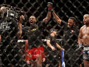 Jon Jones (L) celebrates after defeating Daniel Comier (R) during their light heavyweight title fight at the MGM Grand Garden Arena on January 3, 2015 in Las Vegas, Nevada.