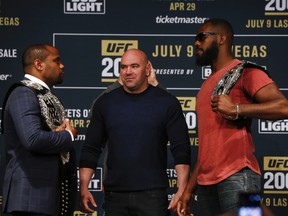UFC president Dana White stars between Daniel Cormier (L) and Jon Jones as they square off during a media availability for UFC 200 at Madison Square Garden on April 27, 2016 in New York City.