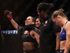 Amanda Nunes (L) of Brazil reacts after defeating Ronda Rousey in their UFC women's bantamweight championship bout during the UFC 207 event at T-Mobile Arena on December 30, 2016 in Las Vegas, Nevada.