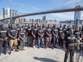 New York City Police Sergeant Edwin Raymond is surrounded by members of law enforcement as he speaks during a rally to show support for Colin Kaepernick, Saturday, Aug. 19, 2017, in New York. Kaepernick, the former quarterback for the San Francisco 49ers, became a controversial figure last year after he refused to stand for the national anthem. He said it was a protest against oppression of black people. (AP Photo/Mary Altaffer)