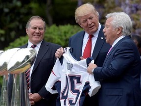 FILE - In this April 19, 2017 file photo, President Donald Trump is presented with a New England Patriots jersey from Patriots owner Robert Kraft, right, and head coach Bill Belichick during a ceremony on the South Lawn of the White House in Washington, where the Patriots were honored for their Super Bowl LI victory. In addition to the jersey, the team confirmed on Tuesday, Aug. 22, 2017, that Kraft decided after the team&#039;s visit to also have a Super Bowl championship ring made for Trump. (AP Ph