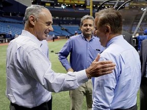 Baseball Commissioner Rob Manfred, left, and Tampa Bay Rays owner Stuart Sternberg, center, meet St. Petersburg Mayor Rick Kriseman before a baseball game between the Rays and the Toronto Blue Jays on Wednesday, Aug. 23, 2017, in St. Petersburg, Fla.