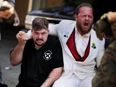 CHARLOTTESVILLE, VA - AUGUST 12:  White nationalists, neo-Nazis and members of the "alt-right" take refuge in an alleyway after being hit with pepper spray after the "Unite the Right" rally was declared an unlawful gathering August 12, 2017 in Charlottesville, Virginia. After clashes with anti-facist protesters and police the rally was declared an unlawful gathering and people were forced out of Lee Park, where a statue of Confederate General Robert E. Lee is slated to be removed.