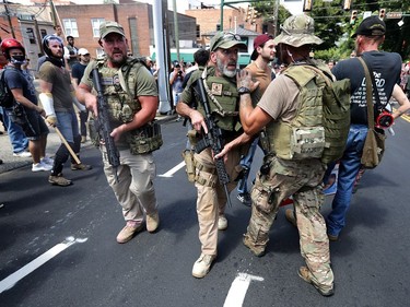 CHARLOTTESVILLE, VA - AUGUST 12:  White nationalists, neo-Nazis and members of the "alt-right" with body armor and combat weapons evacuate comrades who were pepper sprayed after the "Unite the Right" rally was delcared a unlawful gathering by Virginia State Police August 12, 2017 in Charlottesville, Virginia. After clashes with anti-fascist protesters and police the rally was declared an unlawful gathering and people were forced out of Lee Park, where a statue of Confederate General Robert E. Lee is slated to be removed.