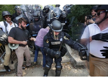 CHARLOTTESVILLE, VA - AUGUST 12:  White nationalists, neo-Nazis and members of the "alt-right" clash with police as they are forced out of Lee Park after the "Unite the Right" rally was declared an unlawful gathering August 12, 2017 in Charlottesville, Virginia. After clashes with anti-facist protesters and police the rally was declared an unlawful gathering and people were forced out of Lee Park, where a statue of Confederate General Robert E. Lee is slated to be removed.