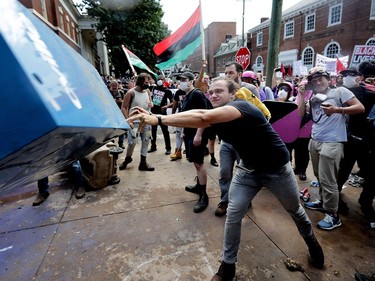 CHARLOTTESVILLE, VA - AUGUST 12:  An anti-fascist counter-protester hurls a newspaper box toward white nationalists, neo-Nazis and members of the "alt-right" during the "Unite the Right" rally outside Lee Park August 12, 2017 in Charlottesville, Virginia. After clashes with anti-fascist protesters and police the rally was declared an unlawful gathering and people were forced out of Lee Park, where a statue of Confederate General Robert E. Lee is slated to be removed.