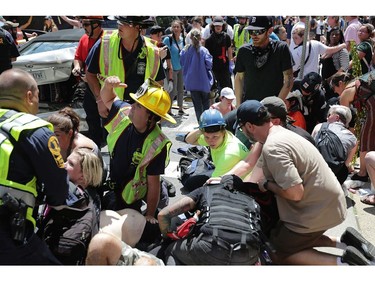 CHARLOTTESVILLE, VA - AUGUST 12:  Rescue workers and medics tend to many people who were injured when a car plowed through a crowd of anti-facist counter-demonstrators marching through the downtown shopping district August 12, 2017 in Charlottesville, Virginia. The car plowed through the crowed following the shutdown of the "Unite the Right" rally by police after white nationalists, neo-Nazis and members of the "alt-right" and counter-protesters clashed near Lee Park, where a statue of Confederate General Robert E. Lee is slated to be removed.