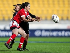 Elissa Alarie of Canada passes in the tackle of Renee Wickliffe of New Zealand during the Women's International Test match between the New Zealand Black Ferns and Canada in  June at Westpac Stadium in Wellington, N.Z.