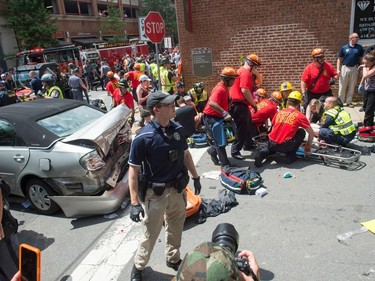 A woman is received first-aid after a car accident ran into a crowd of protesters in Charlottesville, VA on August 12, 2017.  A picturesque Virginia city braced Saturday for a flood of white nationalist demonstrators as well as counter-protesters, declaring a local emergency as law enforcement attempted to quell early violent clashes.