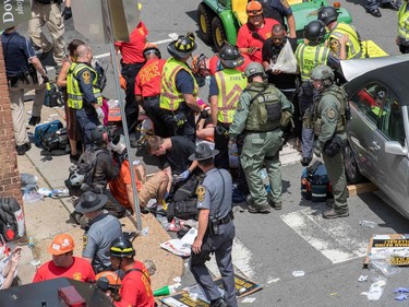 People receive first-aid after a car accident ran into a crowd of protesters in Charlottesville, VA on August 12, 2017.  A picturesque Virginia city braced Saturday for a flood of white nationalist demonstrators as well as counter-protesters, declaring a local emergency as law enforcement attempted to quell early violent clashes.