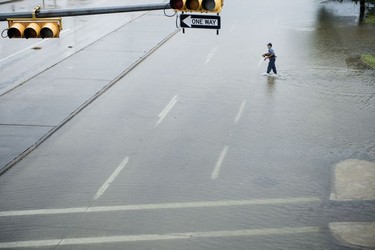 A man walks across a partially flooded street during the aftermath of Hurricane Harvey August 27, 2017 in Houston, Texas.