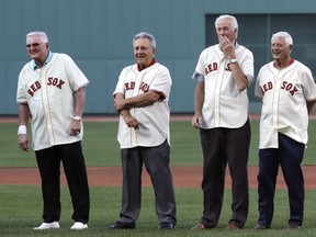 Players from the 1967 "Impossible Dream" Boston Red Sox team watch a ceremony prior to the Red Sox's baseball game against the St. Louis Cardinals in Boston, Wednesday, Aug. 16, 2017. From left are Ken Harrelson, Rico Petrocelli, Jim Lonborg and Carl Yastrzemski.