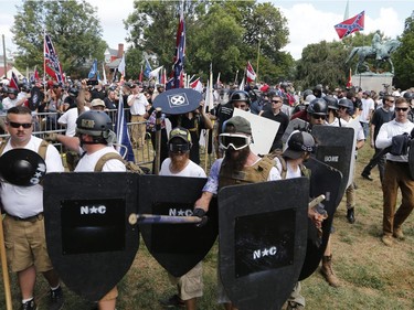 White nationalist demonstrators hold their ground as they clash with counter demonstrators in Lee Park in Charlottesville, Va., Saturday, Aug. 12, 2017.  Hundreds of people chanted, threw punches, hurled water bottles and unleashed chemical sprays on each other Saturday after violence erupted at a white nationalist rally in Virginia. At least one person was arrested.  (AP Photo/Steve Helber) ORG XMIT: VASH125
Steve Helber, AP