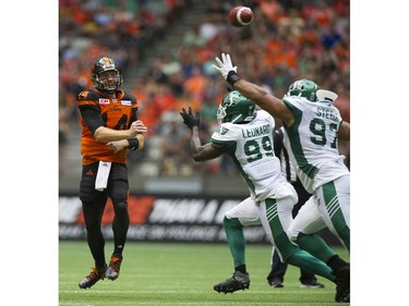 BC Lions #14 Travis Lulay lofts the ball over Saskatchewan Roughriders #99 A.C. Leonard and #97 Eddie Steele in a regular season CHL football game at BC Place Vancouver, August 05 2017.