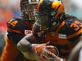 B.C. Lions QB Travis Lulay hands off to Shaq Murray-Lawrence for a touchdown run against the Saskatchewan Roughriders in a regular-season CFL game at B.C. Place Stadium in Vancouver on Aug. 5.