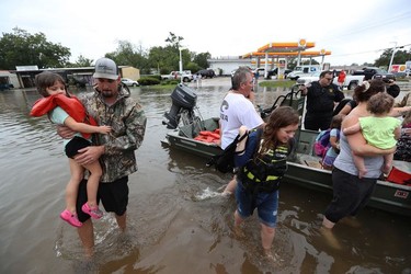 Neighbours use their personal boats to rescue Friendswood, Texas residents stranded by flooding Sunday, Aug. 27, 2017. u