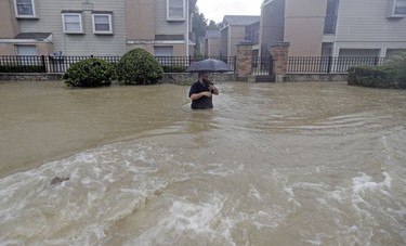 A man wades through floodwaters from Tropical Storm Harvey on Sunday, Aug. 27, 2017, in Houston, Texas.