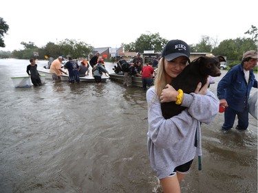 Mikhail Bachynsky hugs her dog Lily after they were rescued from their home Sunday, Aug. 27, 2017, in the Friendswood area of Houston. Neighbours with boats are using their personal boats to rescue Friendswood stranded by flooding.