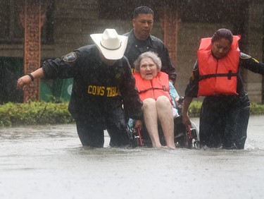 Precinct 6 Deputy Constables Sgt. Paul Fernandez, from left, Sgt. Michael Tran and Sgt. Radha Patel rescue an elderly woman from rising water on North MacGregor Way, near Brays Bayou, after heavy rains from the remnants of Hurricane Harvey, Sunday, Aug. 27, 2017, in Houston. (Jon Shapley/Houston Chronicle via AP) ORG XMIT: TXHOU110

MANDATORY CREDIT
Jon Shapley, AP