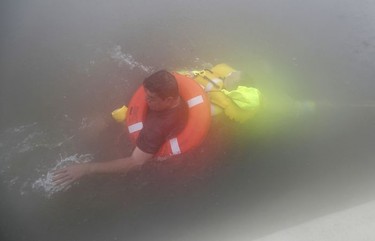 Wilford Martinez, left, is rescued from his flooded car along Interstate 610 in floodwaters from Tropical Storm Harvey on Sunday, Aug. 27, 2017, in Houston, Texas.